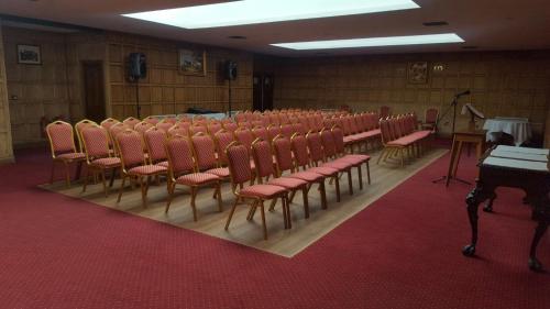 an empty room with chairs and a podium and a microphone at Castle Bromwich Hall; Sure Hotel Collection by Best Western in Birmingham