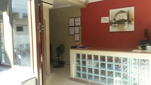 a room with a counter and a red wall at Le Victoria in Vila-de-Santiago-Maior