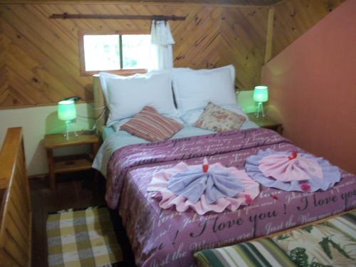 a bedroom with a bed with two candles on it at Chalés Vale Verde in Visconde De Maua