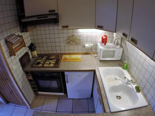 a small kitchen with a sink and a microwave at Studio "Le Panpounet" in Les Contamines-Montjoie