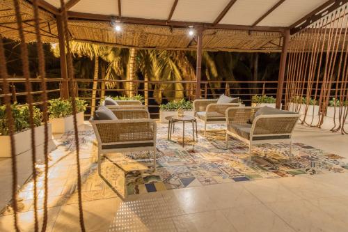 un groupe de chaises et une table sur une terrasse dans l'établissement The Cantamar Beach Hostel, à Santa Marta
