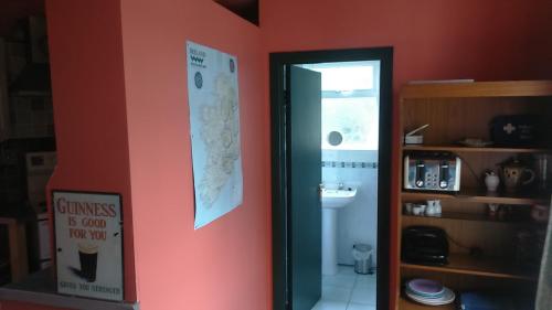 a bathroom with a sign on the wall next to a door at Cosy Lakeside Cottage John's hollow in Headford