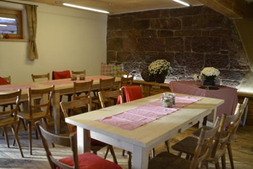 ein Zimmer mit Tischen und Stühlen und einer Ziegelwand in der Unterkunft Fehrenbacherhof Naturgästehaus in Lauterbach