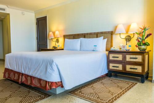 1 cama grande en una habitación de hotel con 2 lámparas en Princess Mundo Imperial Riviera Diamante Acapulco, en Acapulco