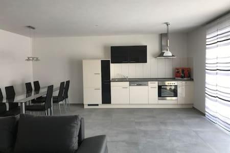 a living room with a kitchen and a table with chairs at Casa Friedolin in Friedrichshafen