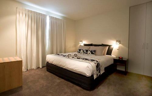 1 dormitorio con cama grande y ventana grande en Focus Motel, en Christchurch