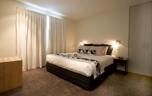a bedroom with a large bed and a large window at Focus Motel in Christchurch