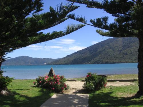 a view of a lake from a park with flowers at Furneaux Lodge in Endeavour Inlet
