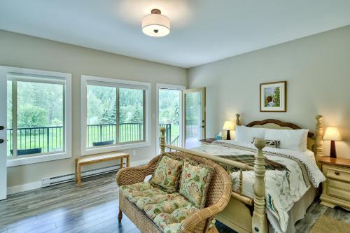 um quarto com uma cama, uma cadeira e janelas em Peaks Bed and Breakfast em Sun Peaks