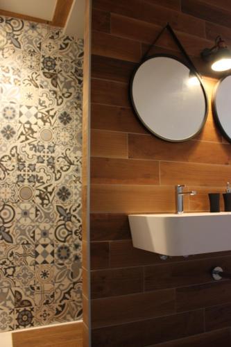 a bathroom with a sink and a mirror at Théière & Couverts - Les Chambres in Cernay