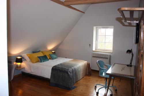 a bedroom with a bed and a table and a window at Théière & Couverts - Les Chambres in Cernay