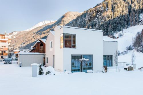 uma casa branca na neve com uma montanha em Laudinella - Apart em See