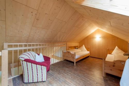 a attic room with a chair and a bed at Laudinella - Apart in See