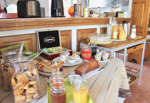 een tafel met eten en drinken in de keuken bij Chambres d'hôtes Le Clos des Oliviers in Sorbo-Ocagnano