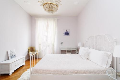 a white bedroom with a white bed and a chandelier at Crystal House in Rome