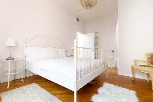a white bedroom with a white bed and a chair at Crystal House in Rome