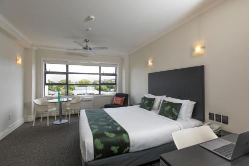 a hotel room with a large bed and a desk at Quest Napier Serviced Apartments in Napier