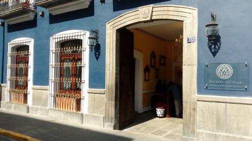 a blue building with an open door and two gates at Hotel Marqués del Ángel in Puebla