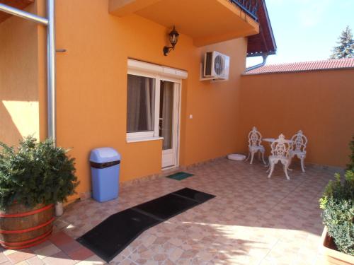 a courtyard of a house with a table and chairs at Gál Apartmanház in Harkány