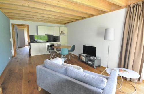 a living room with a couch and a table at Chasa Paoletta in Ramosch