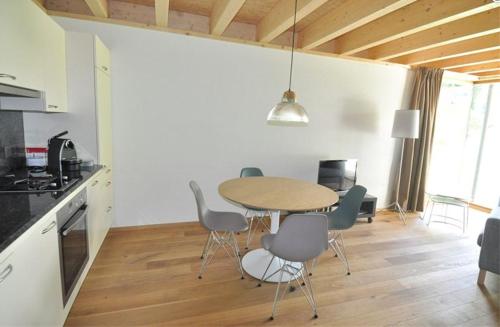 a kitchen and dining room with a table and chairs at Chasa Paoletta in Ramosch