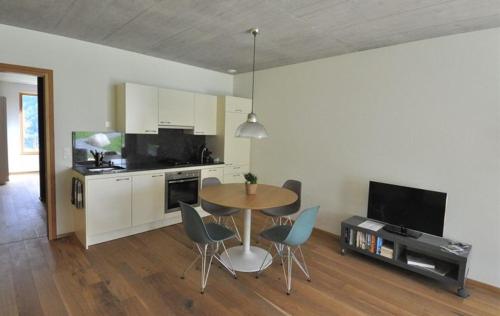 a kitchen and dining room with a table and chairs at Chasa Paoletta in Ramosch