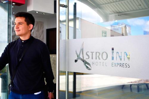 a man standing in front of a hotel sign at Astro Inn Hotel Express in Xalapa