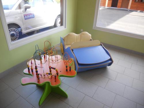 a childs room with a table and a suitcase at Auberge du Saut des Cuves in Xonrupt-Longemer