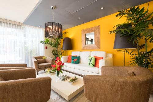 a living room with yellow walls and a white couch at VIVE Hotel Waikiki in Honolulu