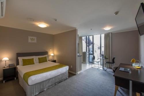 a hotel room with a bed and a desk and a desk at Quest On Ward Serviced Apartments in Hamilton