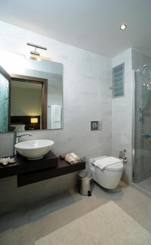 a bathroom with a sink and a toilet and a mirror at Torbahan Hotel in Torba