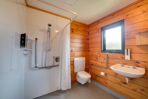 a bathroom with a white toilet and a sink at Wellington TOP 10 Holiday Park in Lower Hutt