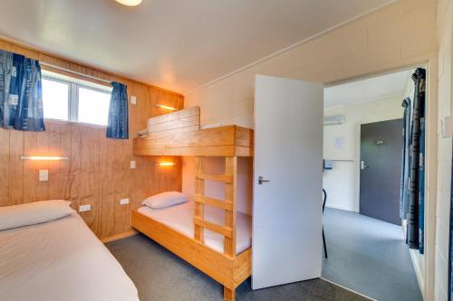 a small bedroom with a bunk bed and a staircase at Wellington TOP 10 Holiday Park in Lower Hutt