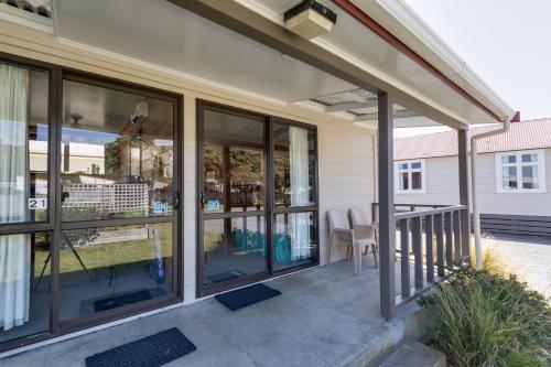 a screened porch with glass windows and a table at Wellington TOP 10 Holiday Park in Lower Hutt