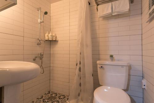 a white bathroom with a toilet and a sink at Neat House in Seoul