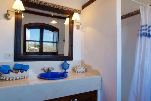 y baño con lavabo azul y espejo. en Villas Macher, en Tías