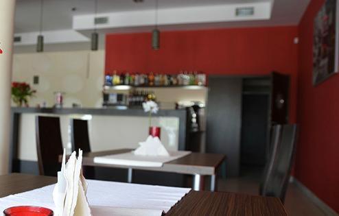 Tokarnia的住宿－希納蒙酒店，一间厨房,配有红色的墙壁、桌子和柜台