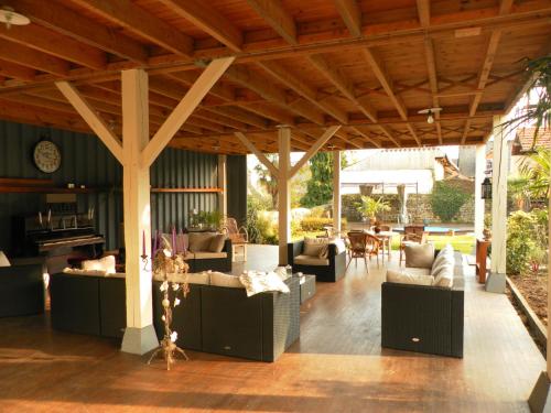 an outdoor living room with couches and tables at Chambres d'Hotes Le 1900 in Val Couesnon