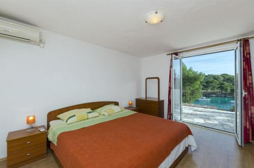 a bedroom with a bed and a large window at Apartments Katja in Primošten