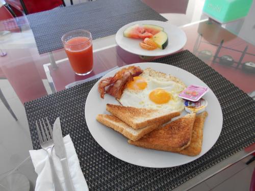 a breakfast of eggs bacon and toast on a table at Silver Fern Beach Retreat in Sekotong