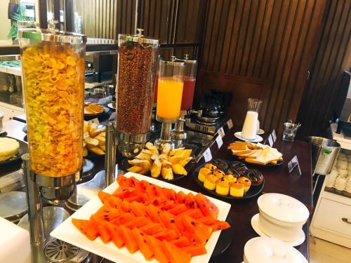a table topped with plates of food and drinks at Ritzy Boutique Hotel Da Nang Beach in Da Nang