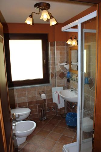 ein Badezimmer mit zwei Waschbecken und zwei Toiletten in der Unterkunft Hotel Tersiva in Valtournenche