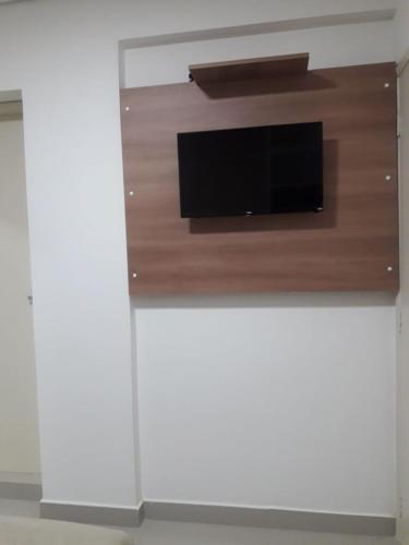 a flat screen tv on top of a white wall at Hotel Morada do Mar in Guarujá