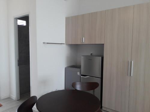 a kitchen with a black table and a refrigerator at TS Beach House in Phu Quoc
