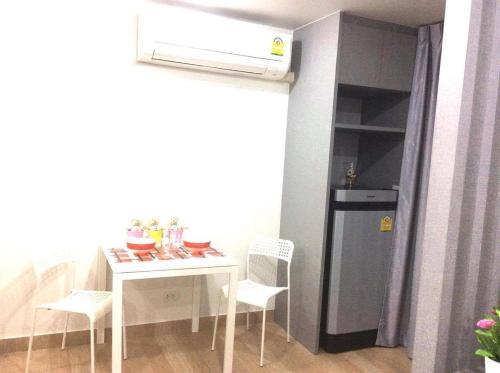 a small kitchen with a table and a refrigerator at Live at Home Sukhumvit 105 in Bangkok
