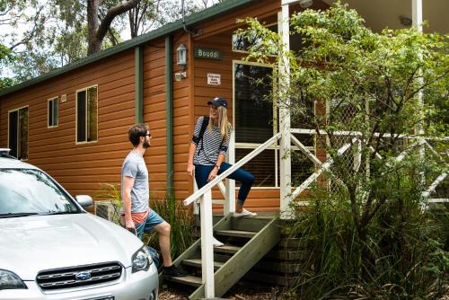 a man and a woman standing on the steps of a tiny house at Discovery Parks - Lane Cove in Sydney