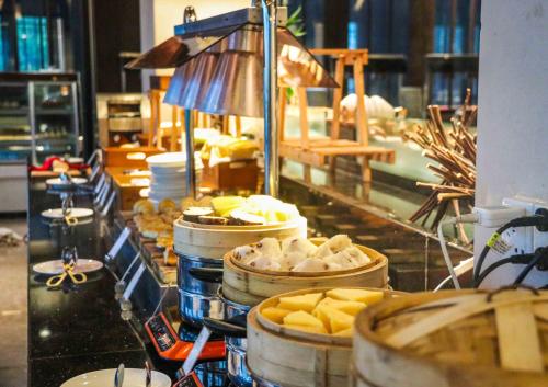 a buffet line with food in barrels on a counter at Narada Resort & Spa Perfume Bay Sanya - All Villas in Lingshui