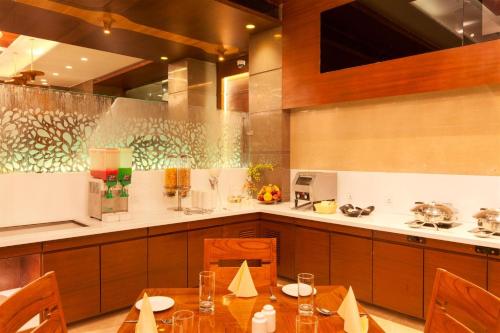 a kitchen with a table with chairs and a counter at Hotel Cosmopolitan in Ahmedabad
