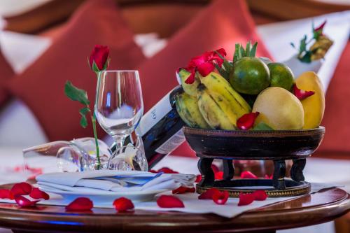 a bowl of fruit on a table with a wine glass at Khemara Angkor Hotel & Spa in Siem Reap