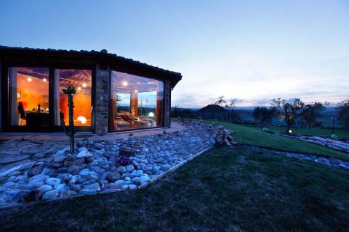 a house with a bunch of rocks in front of it at Bio Agriturismo La Bell'Antiglia in Montemerano